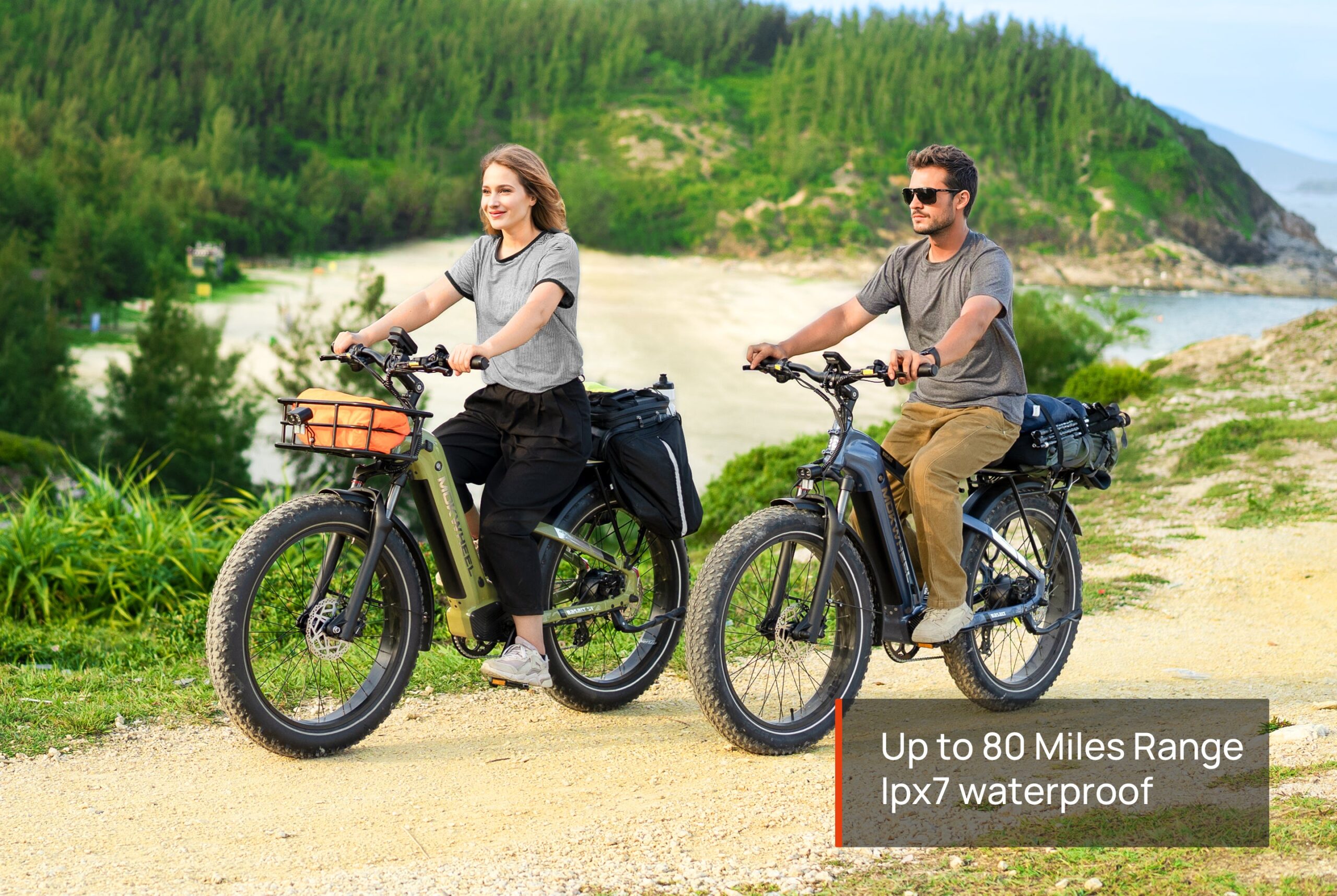 Two riders on Mokwheel Basalt ST 2.0 e-bikes riding a coastal trail, highlighting up to 80 miles of range and IPX7 waterproof rating