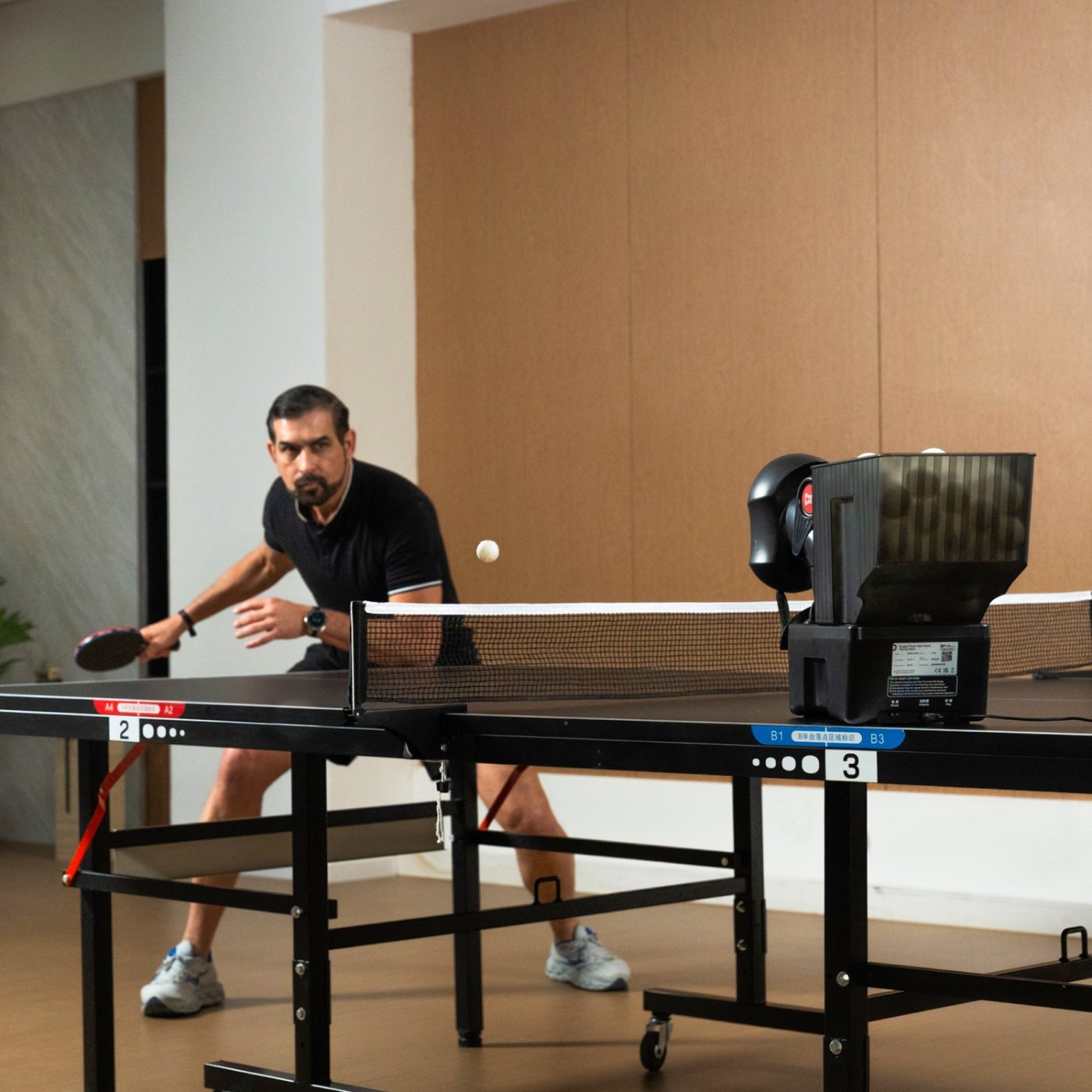 A player practicing against the PONGBOT Nova S Pro table tennis robot